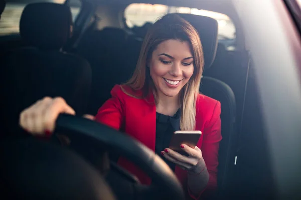Retrato Una Joven Sonriente Conduciendo Coche Usando Teléfono Móvil — Foto de Stock