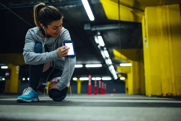 Retrato Uma Mulher Atleta Usando Telefone Celular Estacionamento Subterrâneo — Fotografia de Stock