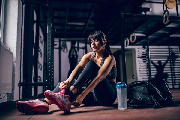 Ταιριάζει Νεαρή Γυναίκα Αθλητής Δένοντας Κορδόνια Παπουτσιών Στο Γυμναστήριο — Φωτογραφία Αρχείου