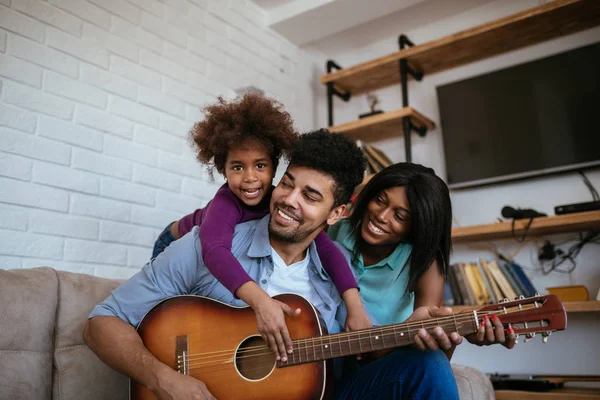 A happy black family playing and singing songs together.