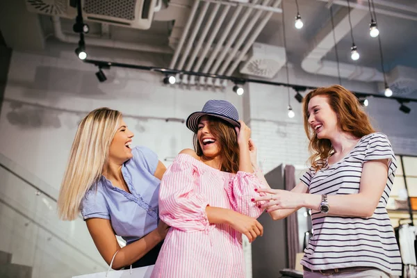 Schot Van Gelukkig Drie Vrouwen Die Proberen Een Hoed Winkel — Stockfoto