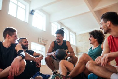 Sahada oturan ve bir takım toplantısı basketbolcular,