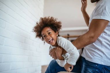 Afrika kökenli Amerikalı küçük kız evde baba ile eğleniyor.