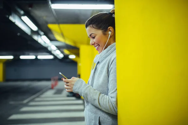 Portret Stronie Uśmiechający Się Kobiety Lekkoatletka Przy Użyciu Telefonu Komórkowego — Zdjęcie stockowe