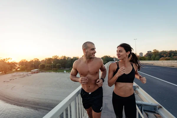 An extremely fit couple enjoying their morning run together.