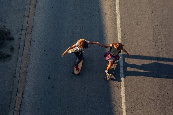 Twee Meisjes Hand Hand Tijdens Het Rijden Een Lange Boord — Stockfoto
