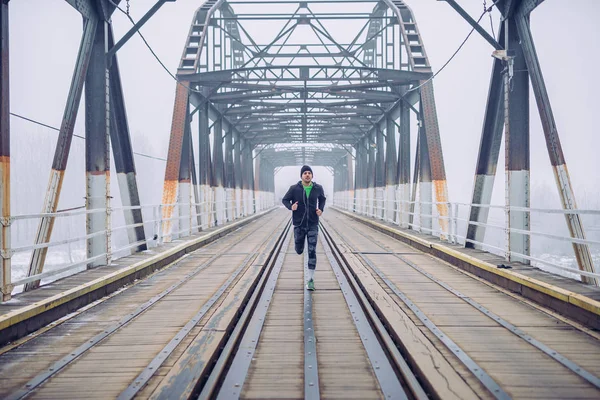 一张在火车桥上奔跑的男子的照片 — 图库照片