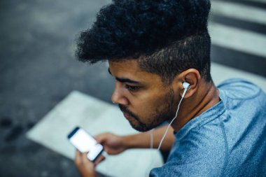 Müzik ve cep telefonuyla bir atlet adam portresi kapatın.