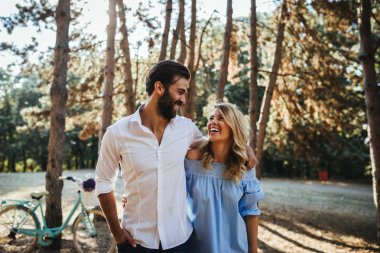 Mutlu çift ormanda yürürken sarılma.