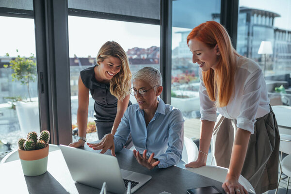 Photo of business women working on a laptop in the office.