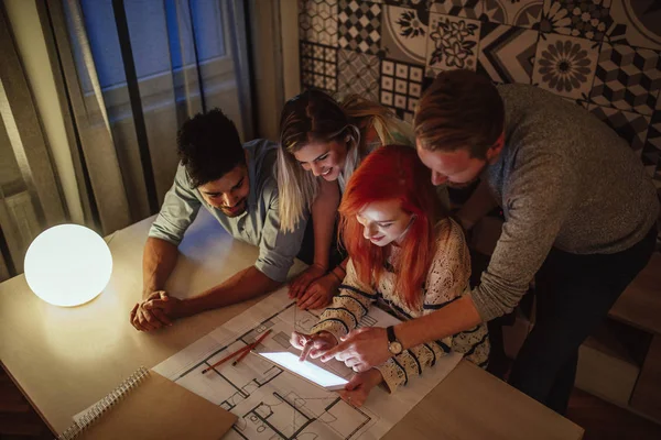 Grupo Arquitetos Casuais Consultando Seu Tablet Durante Uma Reunião Noite — Fotografia de Stock