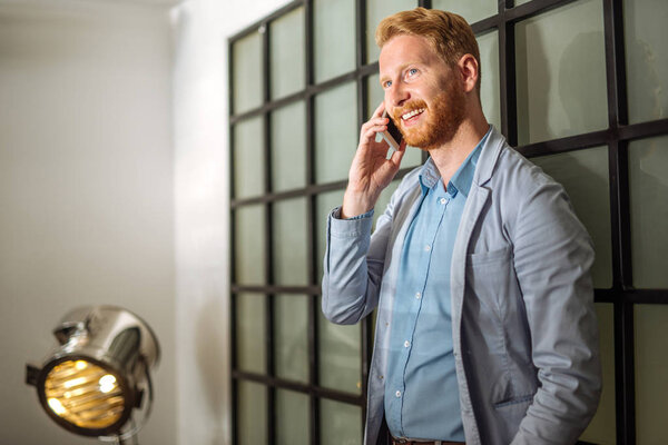 Portrait of a smiling young business man talking on the mobile phone.