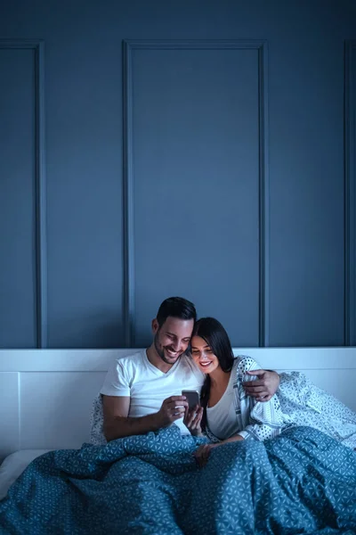Young Couple Cuddling Bed While Browsing Internet Phone — Stock Photo, Image