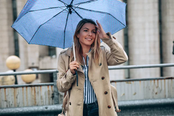Portrait of young woman with an umbrella outdoors.