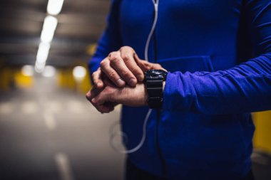 Genç atletik biri başarılı bir eğitimin ardından saatini ayarlama.