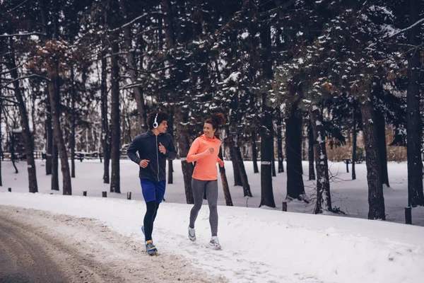 Foto Leende Atletisk Par Som Springer Snön Vinterdag Skogen — Stockfoto