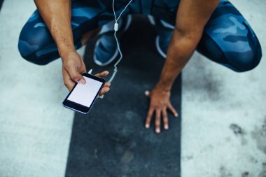 Atletik bir siyah adam telefonunu çalışma dışarı bir mola sırasında tarama.