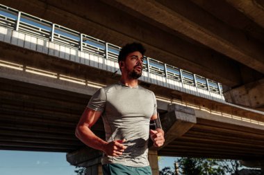 Köprünün altında koşan genç adam