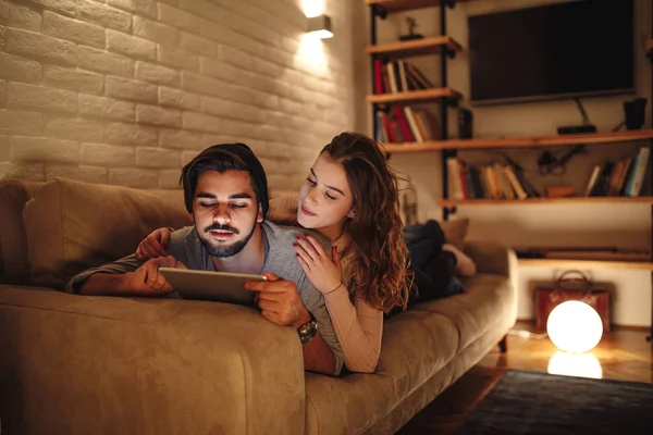 Young Couple Lying Couch Boyfriend Browsing Tablet Movie Watch — Stock Photo, Image