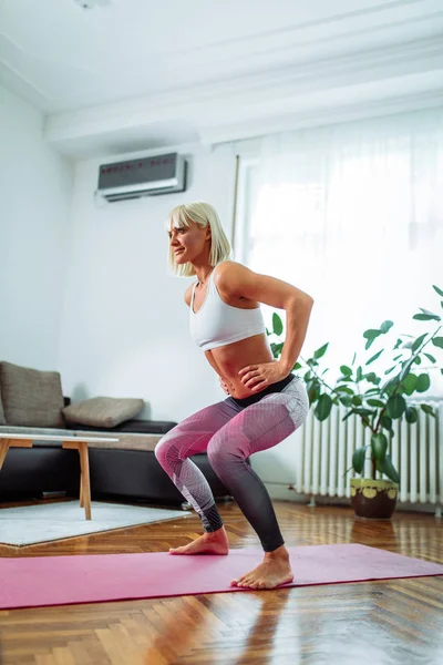 Uma Jovem Mulher Apta Fazer Agachamentos Conforto Sua Casa — Fotografia de Stock