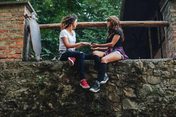 Duas Meninas Sentadas Uma Parede Parque — Fotografia de Stock