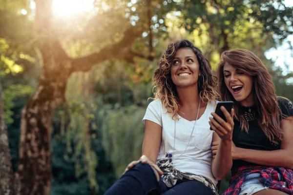 Two Young Girls Sitting Park Looking Mobile Phone — Stock Photo, Image