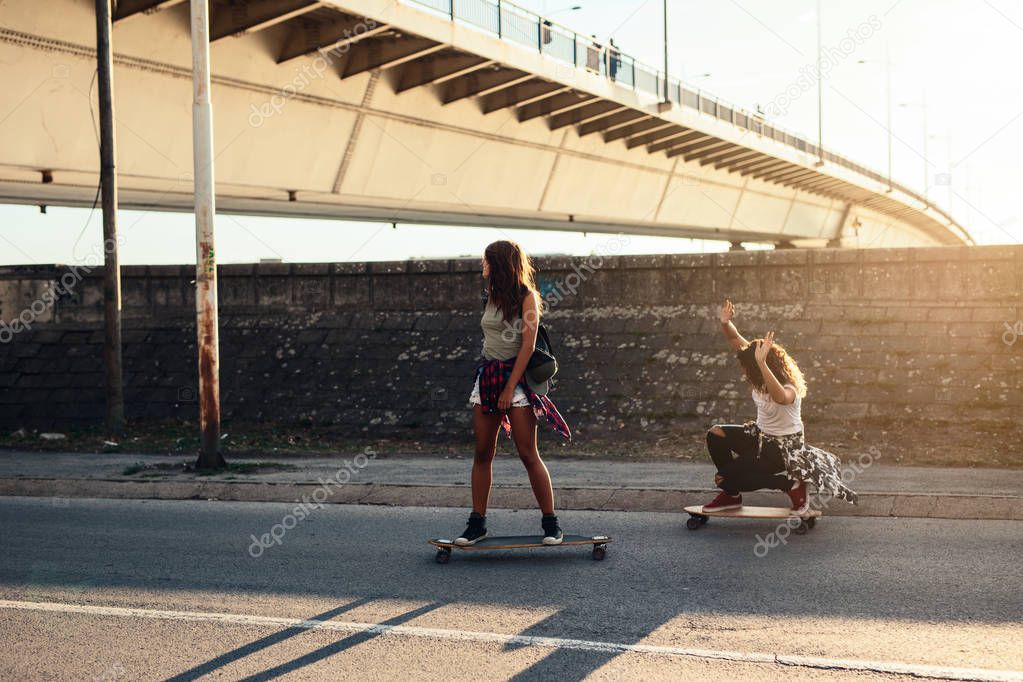 Young girls skateboarding on the road