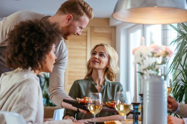 Bruschetti plakalı arkadaşlarına sunan adam