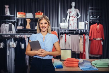 Genç kadın bir dijital tablet tutan bir butik