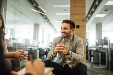 Bir toplantı sırasında gülümseyen genç işadamı atış kırpılmış