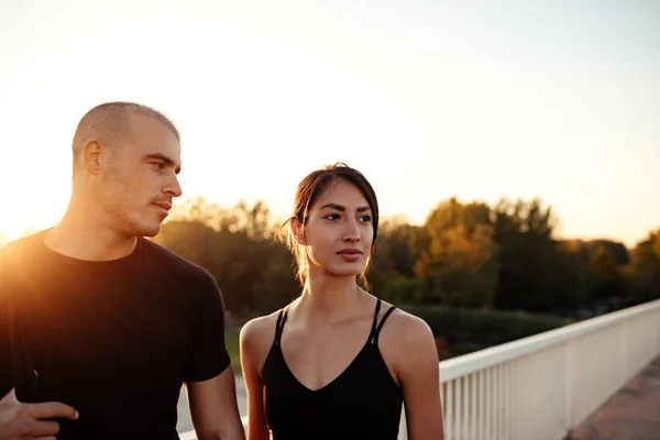 Young sports couple standing on the bridge