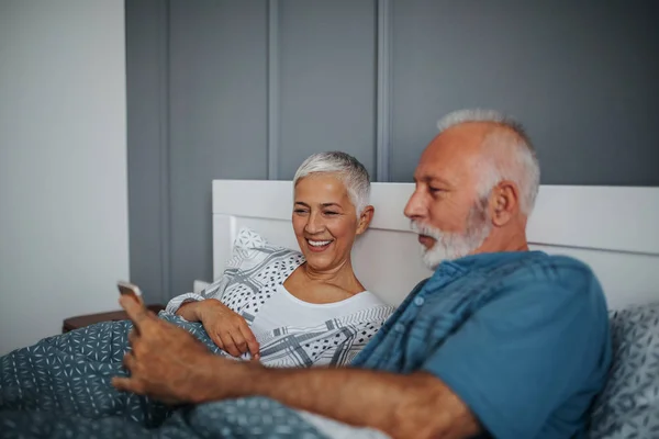 Älteres Ehepaar Liegt Mit Handy Bett — Stockfoto