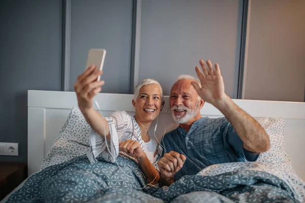 Couple Âgé Couché Lit Tenant Téléphone Portable — Photo