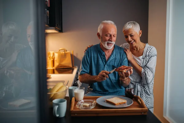Elderly couple having breakfast in the kitchen