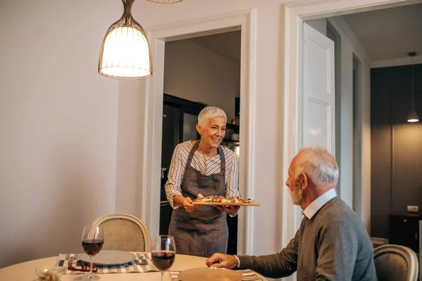 Elderly couple in dining room about to eat