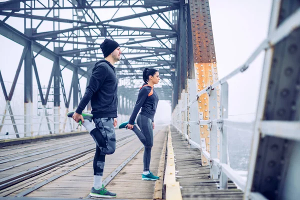 Jovem Casal Alongando Ponte — Fotografia de Stock