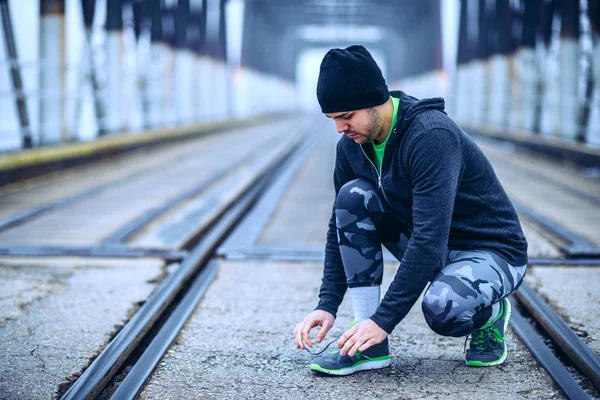 Junger Mann Schnürt Turnschuhe Auf Der Brücke — Stockfoto