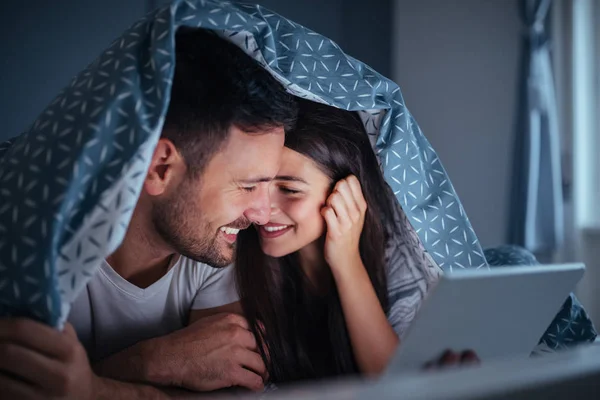 Pareja Joven Acostada Cama Por Noche Sosteniendo Una Tableta — Foto de Stock