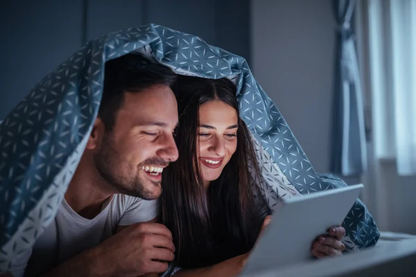 Güzel Genç Bir Çift Bedsheets Altında Yalan Bir Film Izlerken — Stok fotoğraf