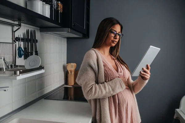 Hermosa Mujer Embarazada Pie Cocina Sosteniendo Una Tableta — Foto de Stock