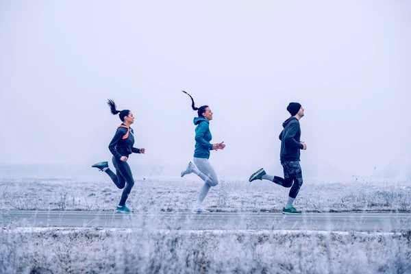 Shot of three people exercising on a winter day — Stock Image Shot Three People Exercising Winter Day Royalty Free Stock Images