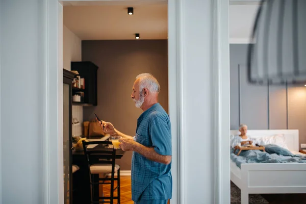 Shot Elderly Man Using Mobile Phone Female Background Enjoying Breakfast — Stock Photo, Image