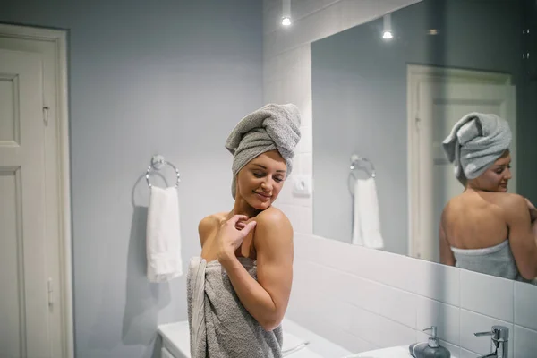 タオルでバスルームに立っている若い女性のショット — ストック写真