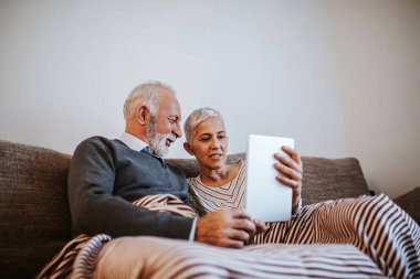 Dijital tablet kullanan yaşlı çift