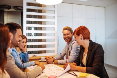 Birlikte ofiste çalışan iş adamları gülümseyen.