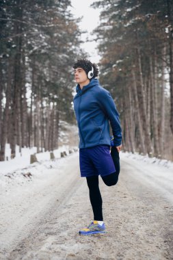 Genç atlet dışında bir kış gününde germe