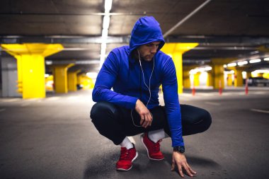 Park yerinde çömelmiş genç sporcu