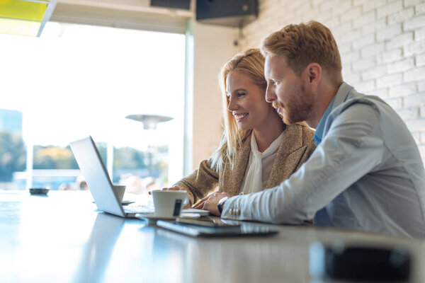 Коллеги, работающие вместе за компьютером в кафе
.