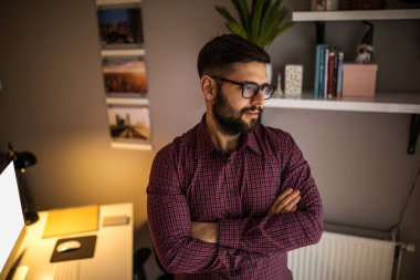 Kollarını çapraz duran bir gurur genç işadamı portresi.