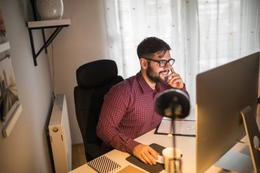 Ofiste bir bilgisayarda çalışan yakışıklı tasarımcı.